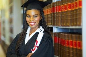 beautiful african female graduate in library on graduation day