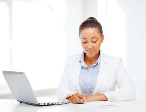 business and technology concept - african businesswoman with lap