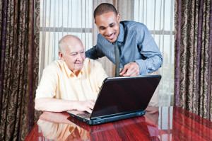Young Man And Senior Male Working On Computer