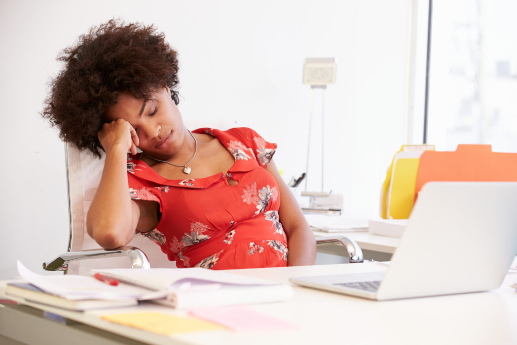 Tired Woman Working At Desk In Design Studio