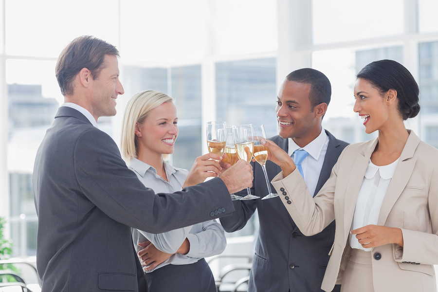 Business team celebrating with champagne and toasting in the off
